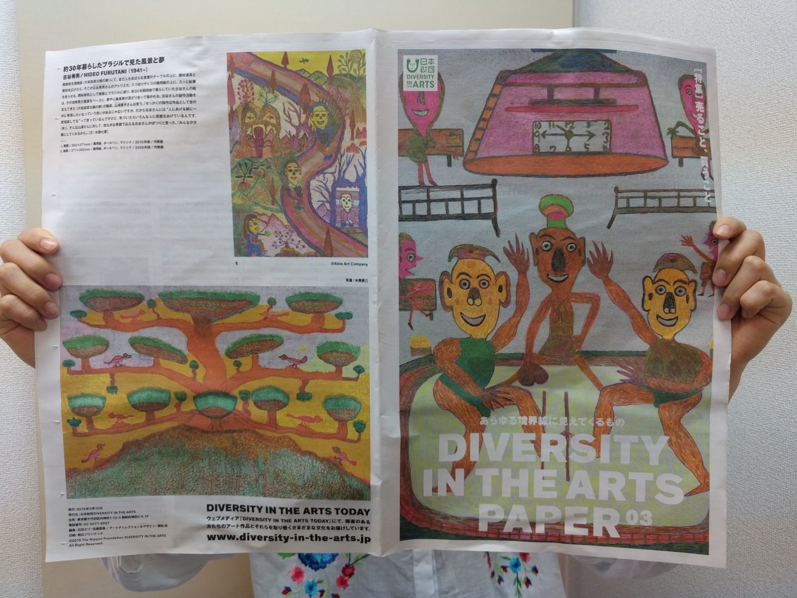 【画像】DIVERSITY IN THE ARTS PAPER 03を両手で広げている
