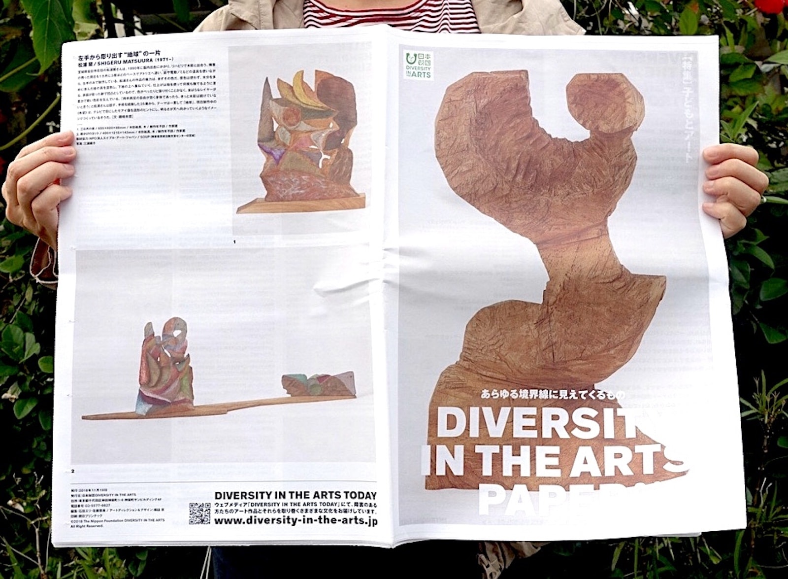 【画像】DIVERSITY IN THE ARTS PAPER 04を両手で広げている