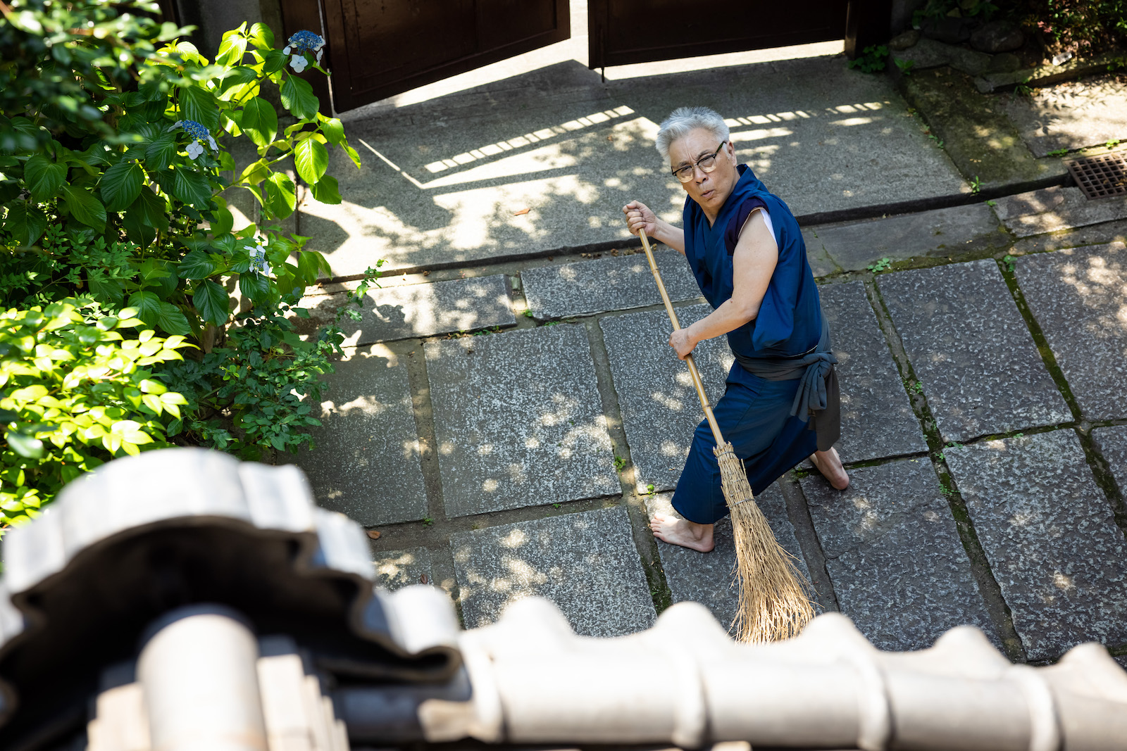 [Photograph] ほうきを手に上を見上げるイッセー尾形さん