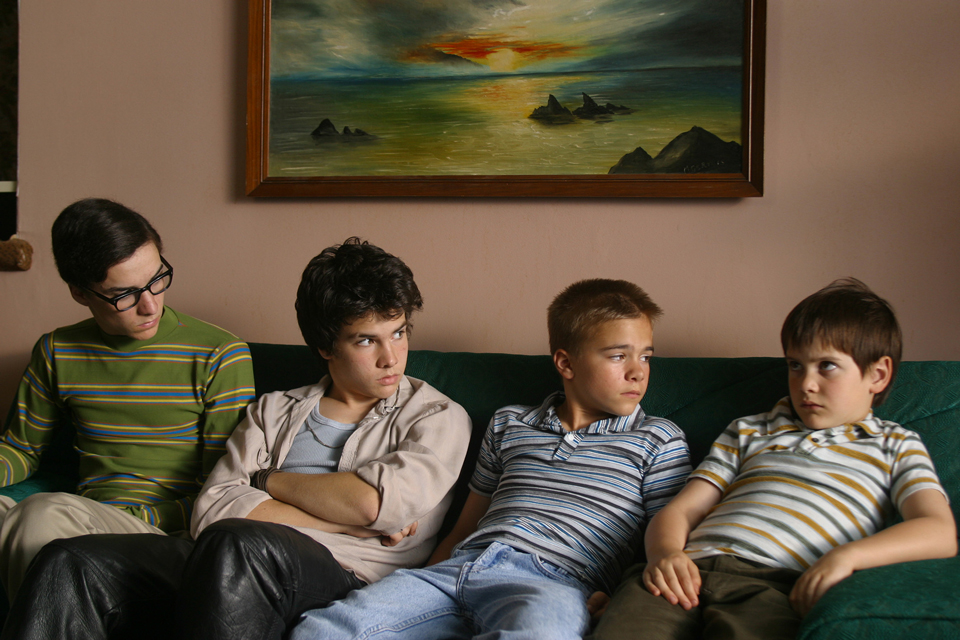 【写真】3人の兄とともにソファに座る少年時代のザック。兄弟たちが怪訝そうな顔でみつめる。