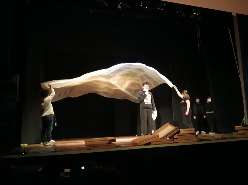 【写真】白い布が広がる背景で、役者が話している舞台の様子