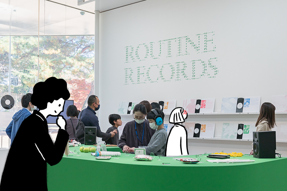 【写真】ルーティン・レコーズの展示室のシティさんとダイバーさん。中央の緑色のテーブルの上にいろいろなものが並び、壁面にはレコードが飾ってある。
