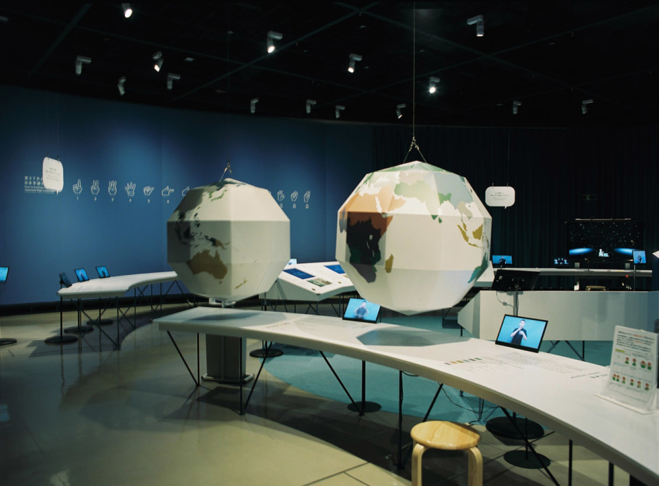 【写真】地球をかたどった多面体オブジェがぶら下がった展示空間