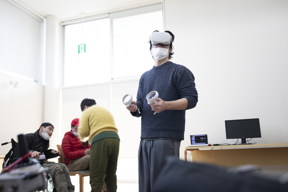 【写真】VRゴーグルを付けている男性が中央にいる。彼はダンサーでVRを使ったダンス表現を構想している。