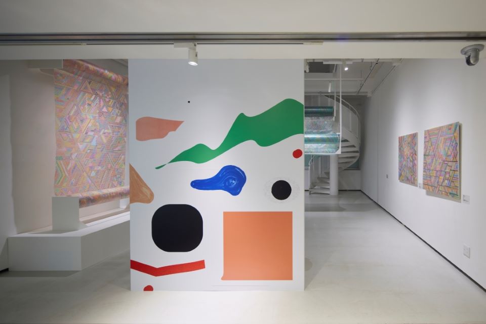 【写真】展示風景、左右の壁に緩衝材を用いたカラフルな、東本憲子さんの作品が展示されている。