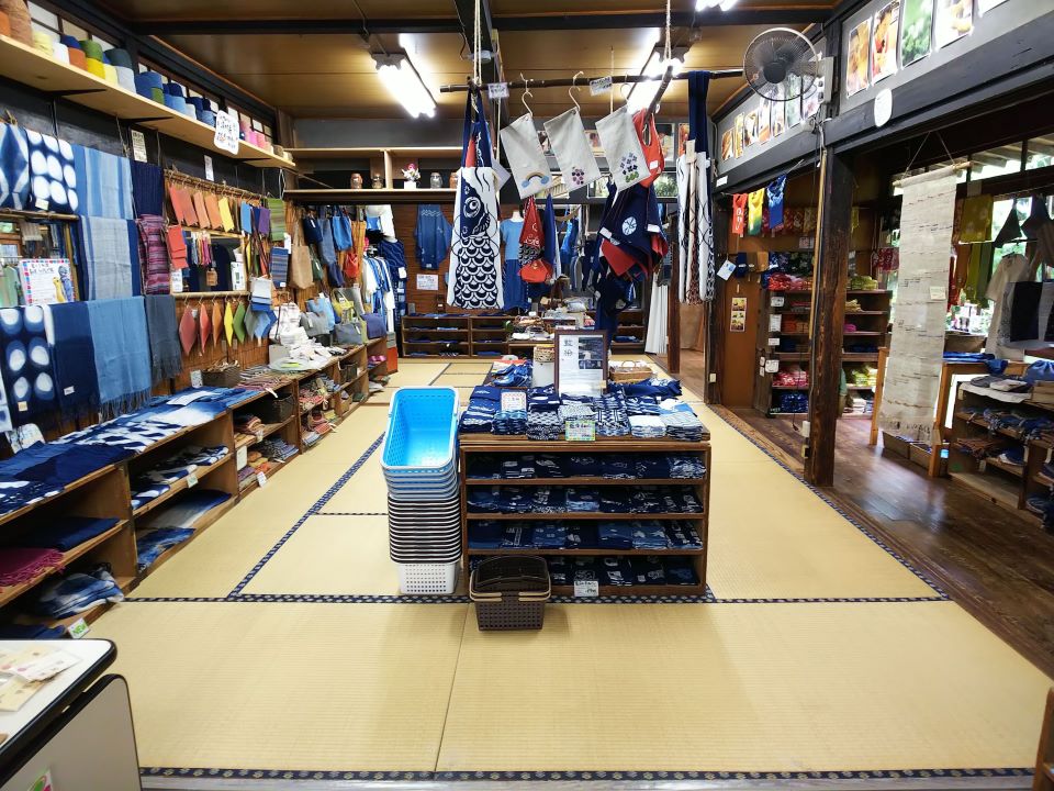 【写真】展示即売会の部屋の様子。畳の広い部屋に大きな部屋の中に、商品が綺麗に並べられ、手前には買い物籠が置かれている