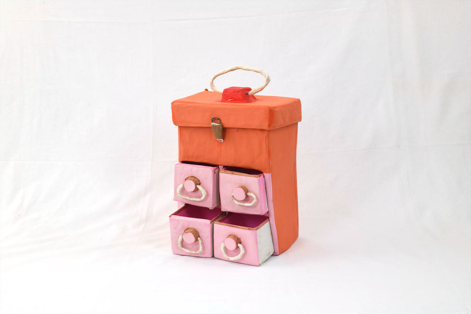 【作品画像】オレンジ色の縦長の箱に、4つのピンクの引き出しがついている。少し歪な形をしている。