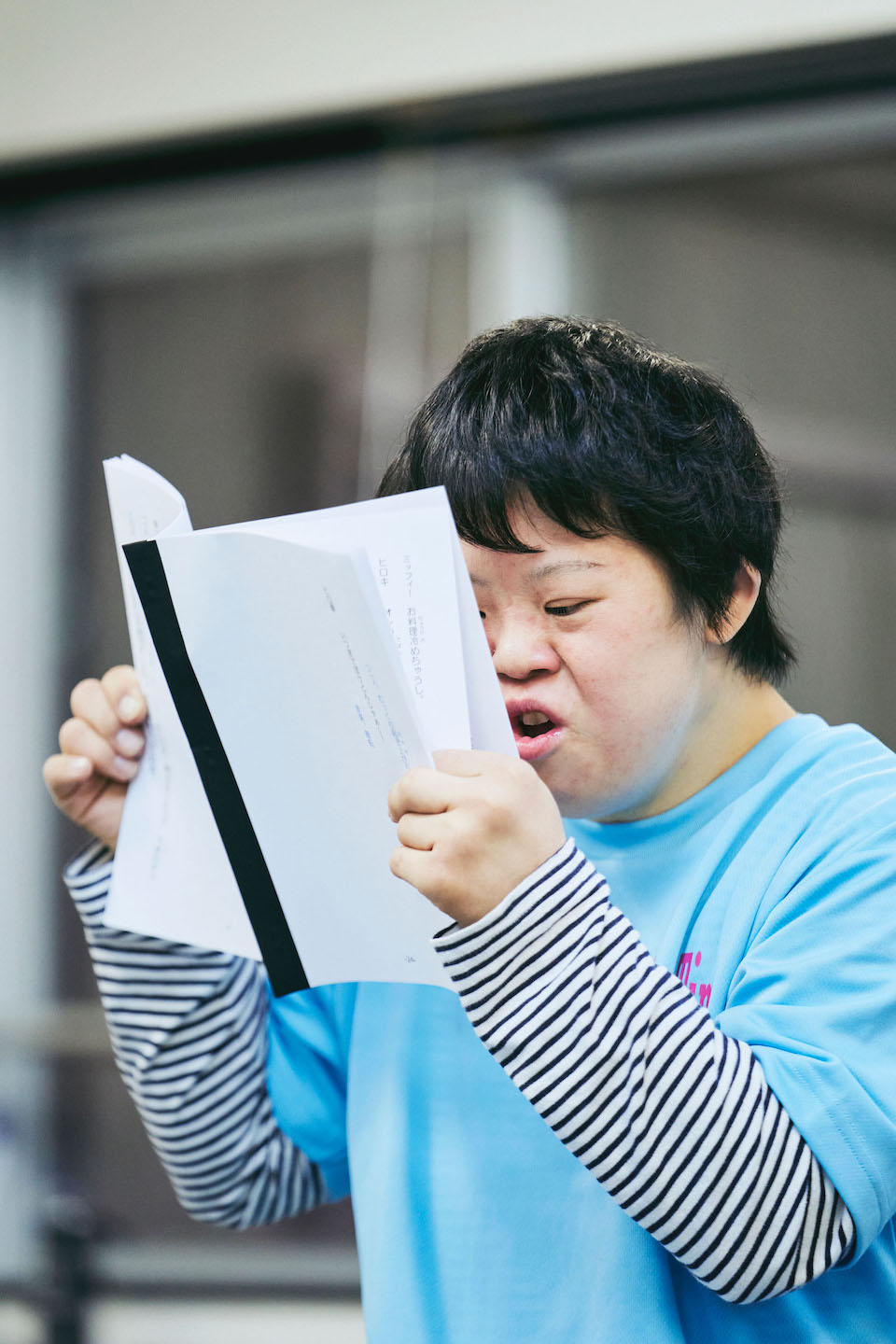 【写真】小澤さんが台本を両手に持ち、顔に近づけて読む様子